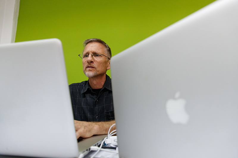 Mark Penner working on a laptop.