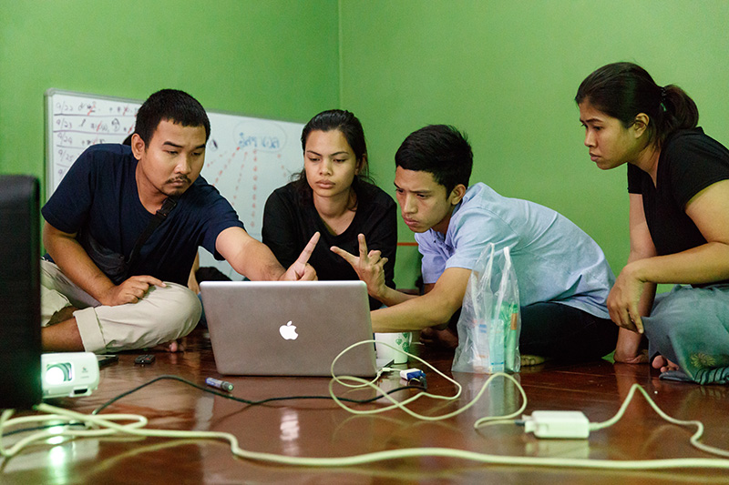 Tum and other translators looking at a computer.