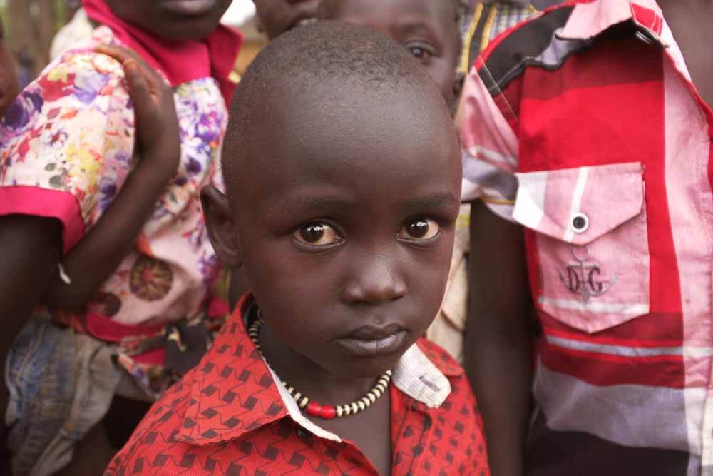 Little boy surrounded by other children.