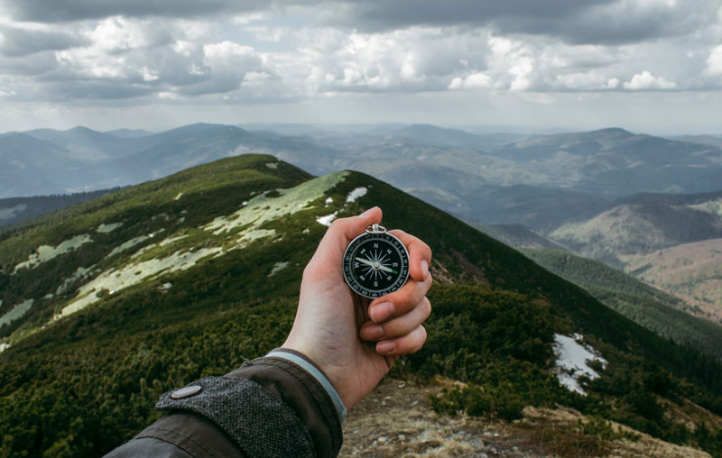Hand holding compass.