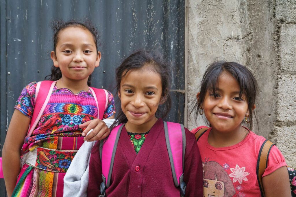 Three Guatemalan children smiling.