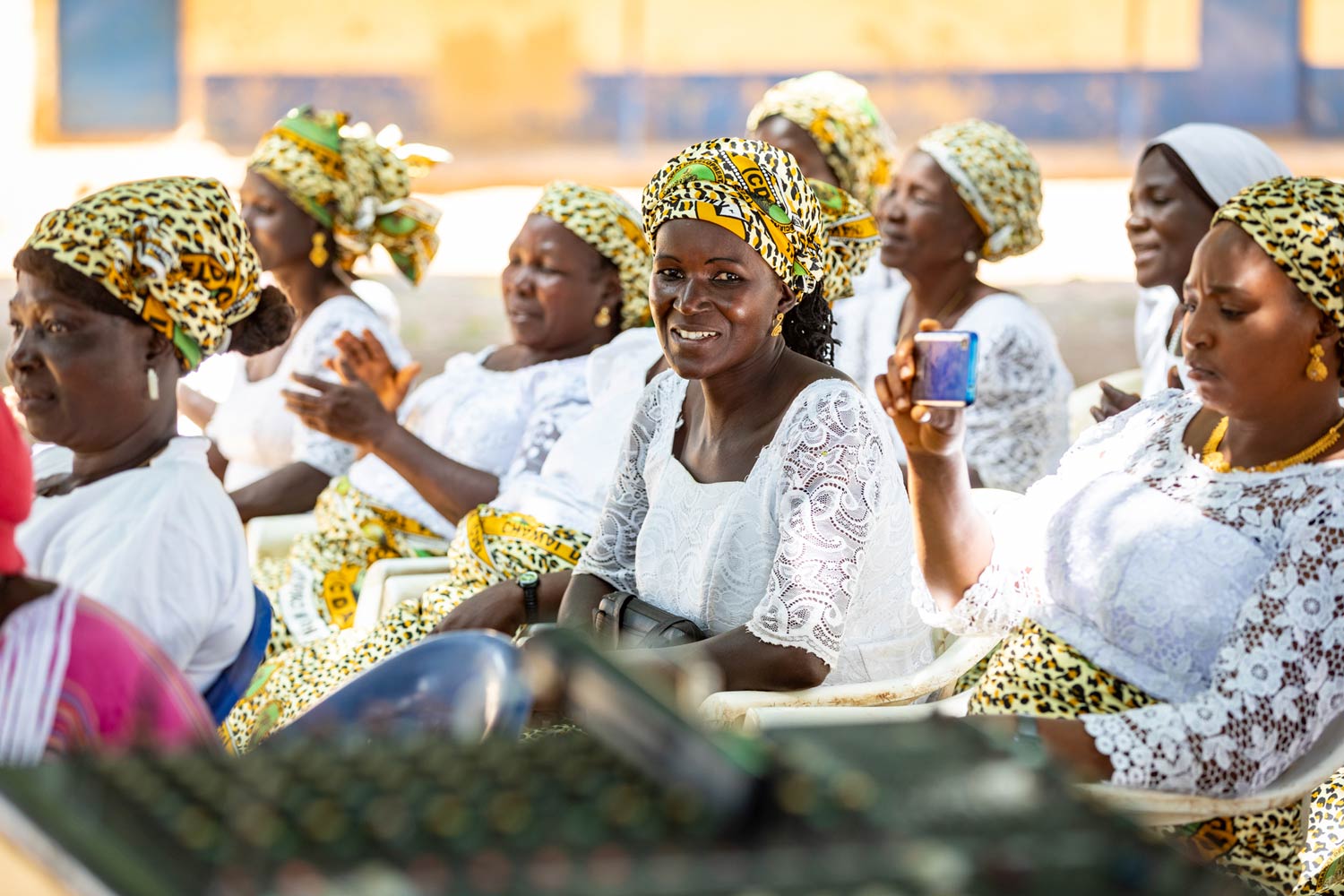 /></figure>
<p class= Africa Nigeria group of women seated wearing white lace with colorful scarves