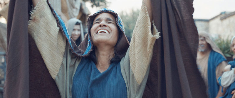 Woman with arms raised in prayer in a scene from “JESUS: a Deaf Missions film.”