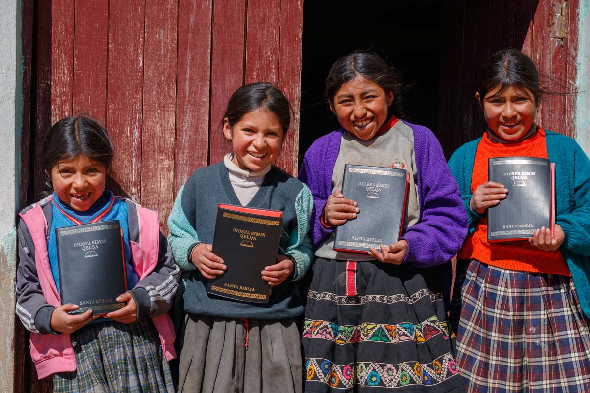/></figure>
<p>Seeds planted in communities around the world over the past several decades have taken root and are now producing an abundant harvest. People whose lives were first <a href= In Peru, girls holding Quechua Bibles