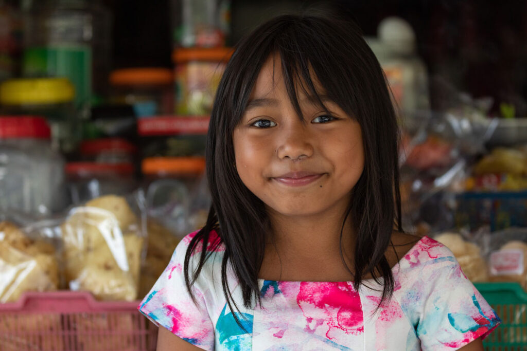 Little girl smiling at a market.