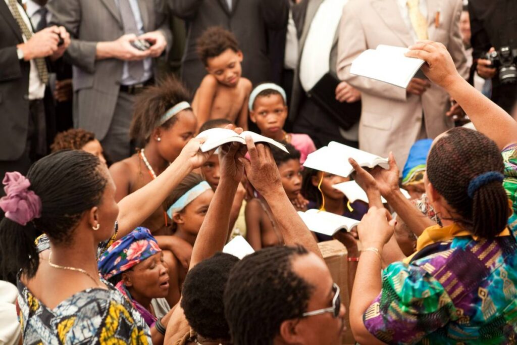 Hands holding up Bibles.